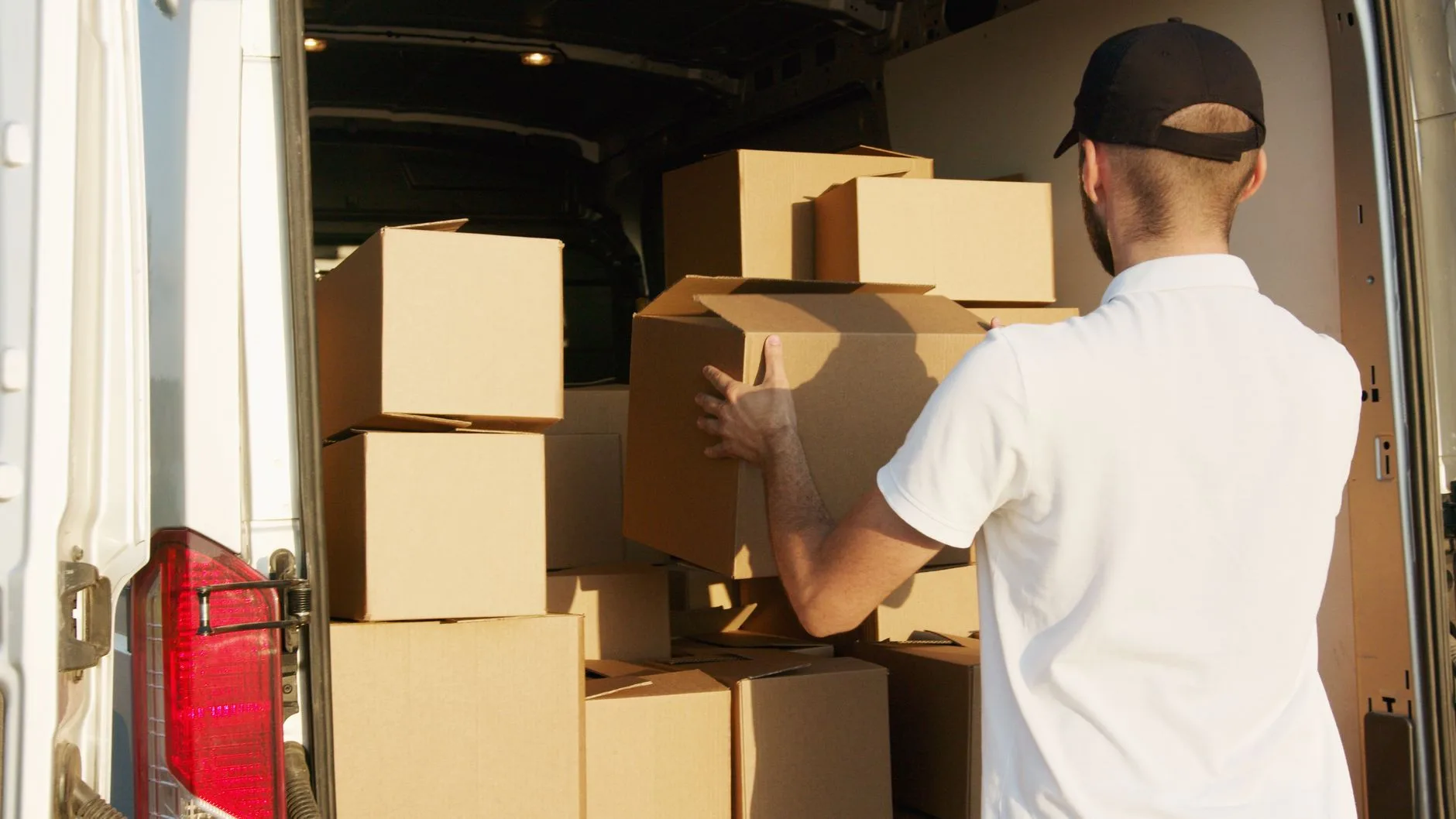 Déménageur chargeant des cartons dans un utilitaire pour un transfert de bureaux